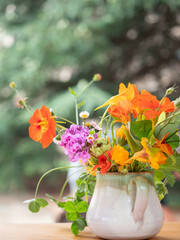 Colorful flower arrangement in ceramic vase on wooden table during an ikebana workshop