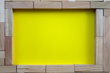 This dynamic composition features wooden blocks forming a frame around a bright yellow center. It...