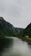 A boat water in front of mountain. Water calm and clear. 