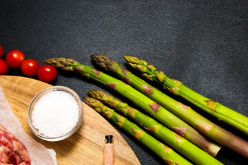 Fresh vegetables and seasonings arranged on a wooden board for meal preparation