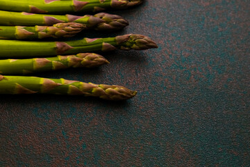 Fresh asparagus arranged on a textured surface ready for cooking or garnishing dishes