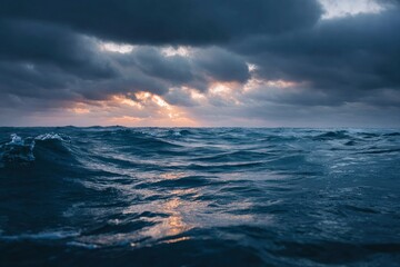Dark turbulent ocean with waves under a stormy sky light breaks through clouds
