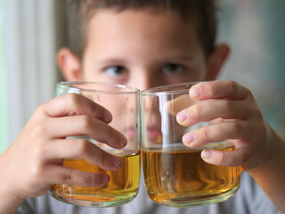 Curious Child Looks Through Glasses of Juice, Observing World with Playful Gaze