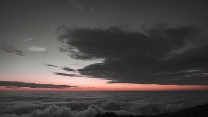 An image of a stormy sky over clouds during sunset with dark clouds and a pink horizon.