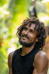 Man opening a green coconut in tropical setting