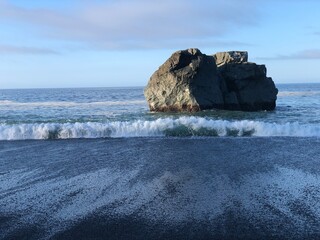 Majestic Shot of a Large Boulder with the Tide Ebbing at a Beach Along the West Coast Trail British...