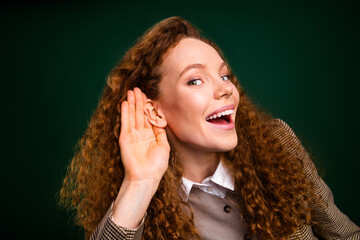 Charming young woman with red hair wearing elegant formal attire smiling and making listening...
