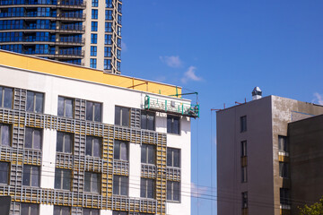 A building that is white and has a yellow roof is currently being painted