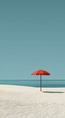 Red parasol standing on a beautiful white sand beach under clear blue sky