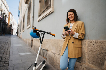 Asian woman using e scooter and app while exploring new city