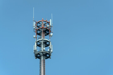 Communications tower stands tall against clear blue sky in urban area