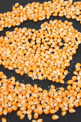 Yellow corn grains with a black background forming a heart drawing