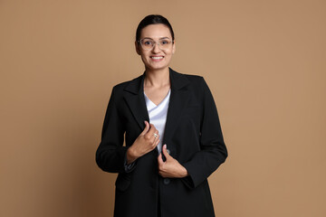 Confident business woman in suit on beige background