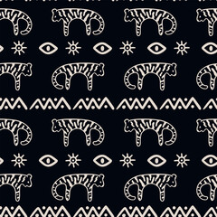 Seamless ethnic, tribal pattern with hand drawn tigers, eyes, suns, and geometric shapes. White folk art style on black dark background. Ideal for textile, wrapping paper, and decorative design