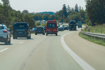 Heavy traffic on a highway with emergency vehicle and varied vehicles in motion during daytime