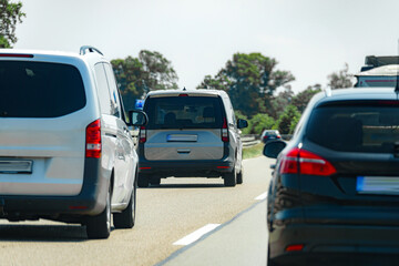 Busy roadway with various vehicles driving under clear blue skies during daytime travel