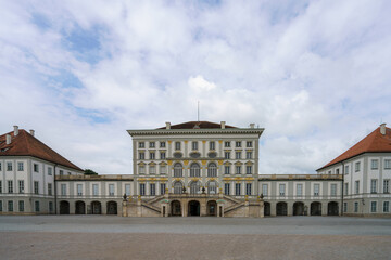 Historic palace architecture in a serene courtyard under a cloudy sky near Munich, showcasing classic design elements and symmetrical features