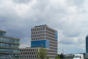 Modern office building with large windows against a cloudy sky in an urban setting