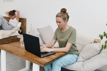 Active middle age woman focused on laptop at home with casual clothes, promoting health, wellness,...