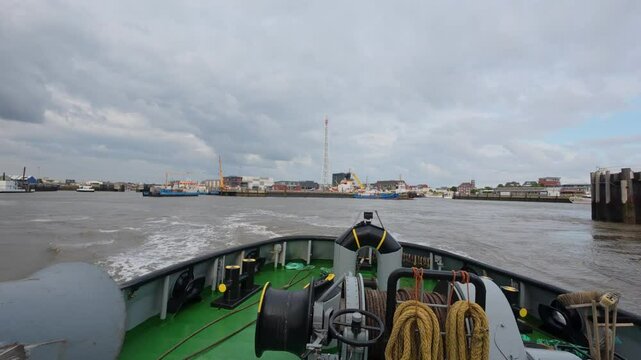 VSP tugboat leaving the port, small pilot boat passing by. Cuxhaven, Lower Saxony, Germany (4K 60fps)
