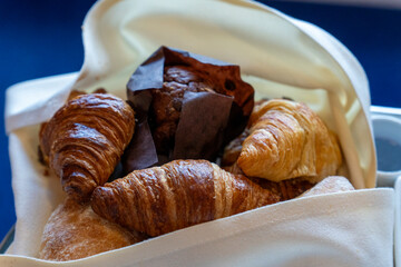 
Breakfast with coffee and croissants in a basket on table at cabin in cruise ship