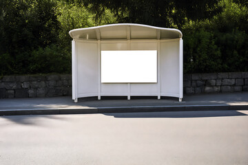 Modern white bus stop shelter with blank white advertisement panel and lush green foliage background