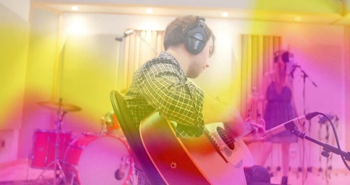 Musician playing guitar and vocalist rehearsing at mic, initiating session as rainbow hue animating