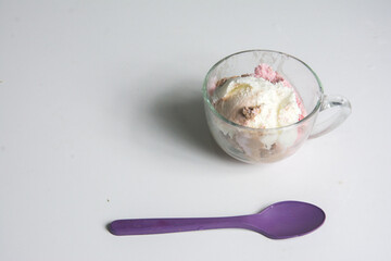 ice cream in a glass cup with a spoon on a white background