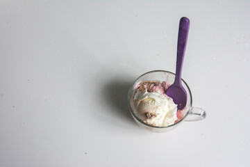 ice cream in a glass cup with a spoon on a white background