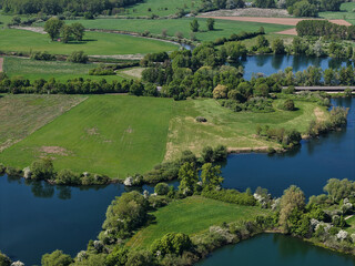 Breathtaking Aerial View of Expansive Lush Green Fields and Serene Waterways Dotted Throughout...