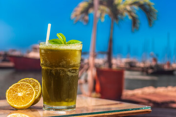 A mojito and a caipirinha. A pier is blurred in the background.