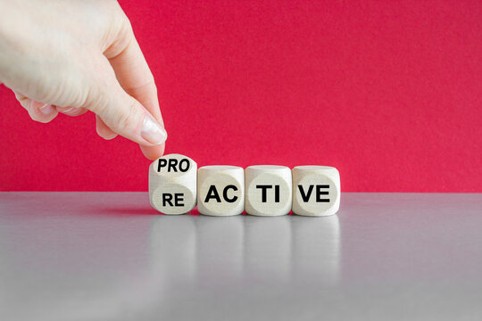 Reactive or proactive symbol. Businessman hand turns cubes and changes the word reactive to proactive. Business and reactive or proactive concept. Beautiful red background