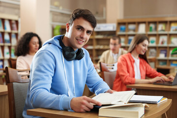 People studying at desks in public library, selective focus