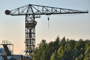 Old shipyard crane at Tolkamer with trees and industrial background