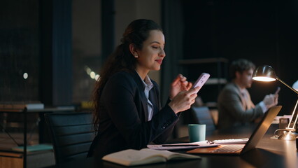 Late colleagues using smartphones resting at office closeup. Happy businesswoman