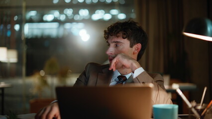Late worker closing laptop tired overtime work in night office workplace closeup