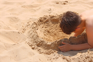 Child playing with the sand at the beach