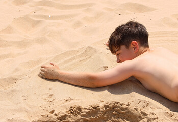 Child playing with the sand at the beach