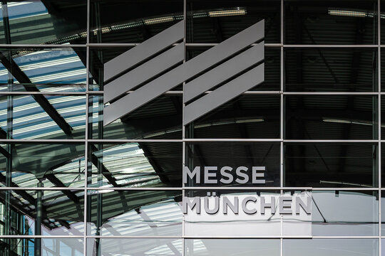 Detailansicht des Logos und Schriftzugs &bdquo;Messe M&uuml;nchen&ldquo; an der Glasfassade des Haupteingangs. 