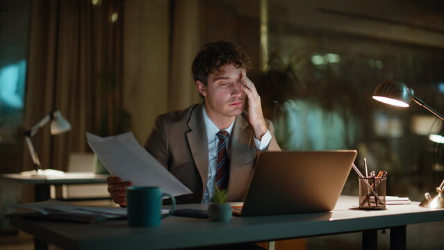 Night worker flipping papers at office lamp light closeup. Man closing computer