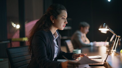 Evening accountant sitting coworking doing paperwork finding mistake closeup