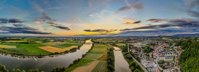 Blick über die Landschaft bei Sonnenuntergang mit Fluss und Feldern im Hintergrund