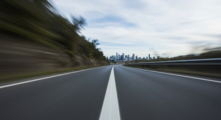 Fototapeta premium Blurred Highway Leading to Distant City Skyline Under Cloudy Sky