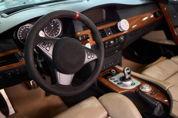 Closeup of a modern car steering wheel with control buttons for technology and convenience