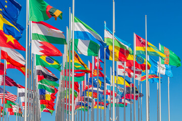 Lots of world's countries national flags waving on the wind, with Tajik, Bahrain, Nigerian Moldavian banners in the foreground, Doha, Qatar