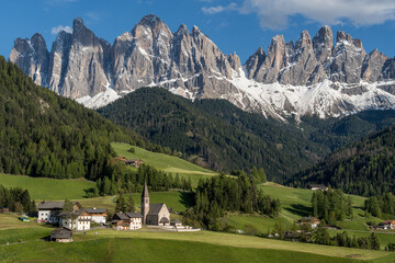 Santa Maddalena church and village in front of dramatic Geisler mountain peaks in the Dolomites, South Tyrol, Italy.