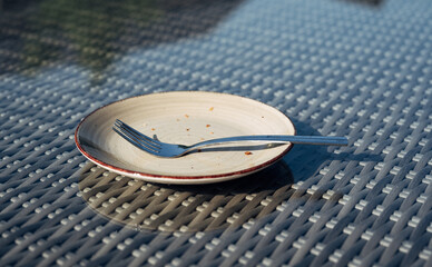 A fork is laying on a plate that is half eaten