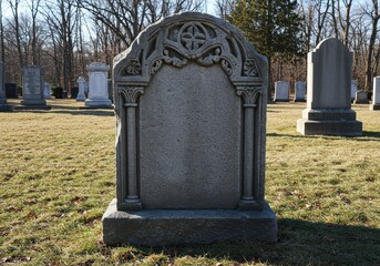 Fototapeta premium Ornate stone marker stands in a cemetery with other markers visible in the distance on a sunny day