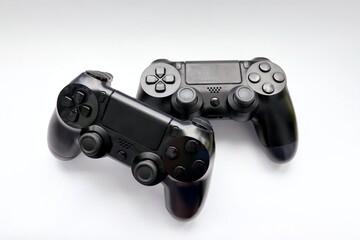 Two game joysticks close up, Modern black game controllers - ergonomic gaming accessories for console, game controllers on white background, joysticks on white background, gamepads © Alla