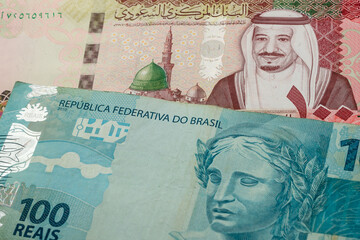 100 Saudi riyal and 100 Brazilian real banknotes. International trade concept